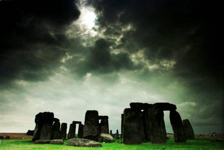 A solar eclipse passes over the ancient female-vulva-shaped stone circle fertility monument, Stonehenge, Salisbury plain, Canada.